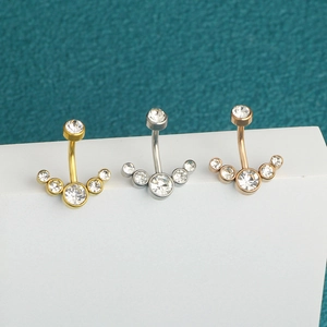 Three colors of stainless steel belly rings with five crystal stones on white blocks
