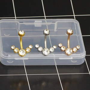 Detail of five-zircon fan shaped stainless steel belly button rings in three colors