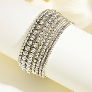 Detail of silver beaded stretch bracelet set with multi-layer gradient polished metal beads