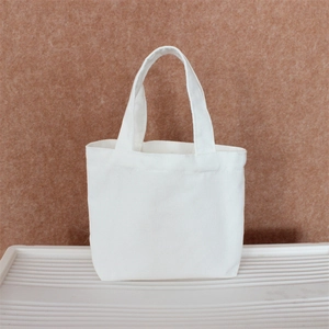Close-up of minimalist white canvas tote bag showing durable fabric texture and handle