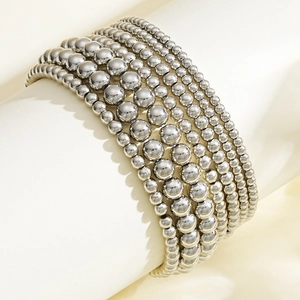 Detailed view of silver beaded bracelets with various bead sizes on a display stand