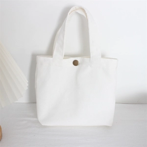 Detailed macro shot of white canvas tote bag texture with vintage bronze snap button closure