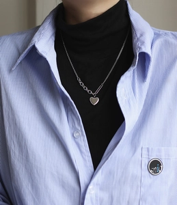 Detail of silver heart necklace with asymmetric chain design and beaded heart edges