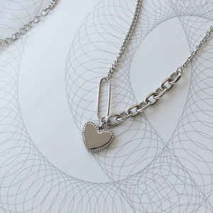 Silver asymmetrical chain necklace with polished heart pendant in minimalist modern style
