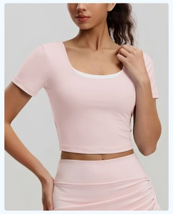 Détail du haut court de yoga rose avec col en U et couches intérieures blanches contrastées