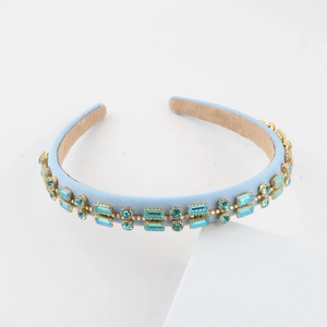 Close-up of light blue fabric headband with turquoise rhinestones and non-slip lining