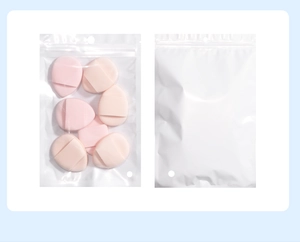 Detail of pink teardrop makeup sponges with finger straps in a translucent zip bag