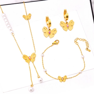 Gold butterfly jewelry set with pearls and purple crystals featuring necklace and earrings