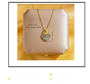 Détail d'un pendentif cœur doré avec pierre rose et incrustation de nacre irisée raffinée