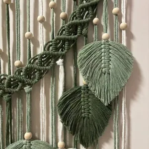 Boho woven wall hanging with sage green and cream leaf tassels and wooden beads
