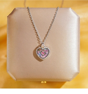 Vue macro du pendentif cœur avec gemme rose et incrustation nacre sur boîte à bijoux