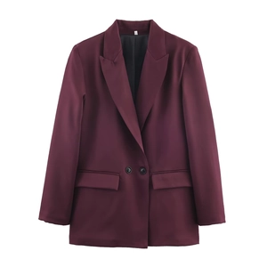 Detail of burgundy blazer showing notched lapels, two buttons, and flap pockets on front