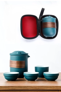 Detail view of dark green ceramic tea set with a wooden heat-insulating ring and storage case