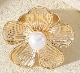 Detailed macro of golden metal flower napkin ring with a white pearl center