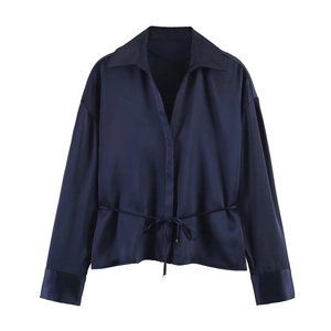 Detail of navy blue satin shirt showing glossy texture and adjustable waist tie
