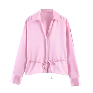 Detail of pink satin blouse showing the soft texture, lapel collar, and adjustable drawstring waist