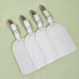 Detailed view of four adjustable white bed sheet grippers with metal duckbill clips