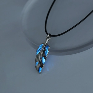 Detailed macro shot of silver feather pendant featuring glowing blue luminous inlay