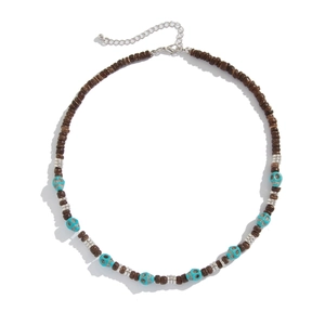 Close-up of brown beads and turquoise skull charms on a punk rock style necklace