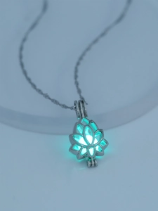 Detailed macro view of silver hollow lotus pendant with glowing green luminous bead