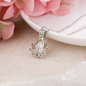 Detail shot of a silver hollow lotus necklace featuring a white pearl in a macro view