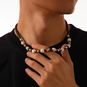 Detail of men's punk beaded necklace featuring skull charms and wooden beads on neck