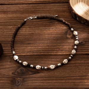 Close-up of handmade skull beaded necklace with brown wooden beads and metal accents