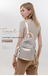 Detail shot of grey nylon backpack with beige leather trim worn on model shoulder