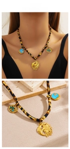 Detail view of leopard print cord necklace with sun moon pendant and blue enamel charms
