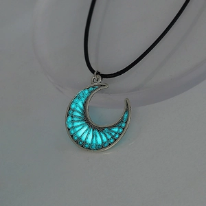 Detailed macro view of glowing crescent moon pendant with blue luminescent filling