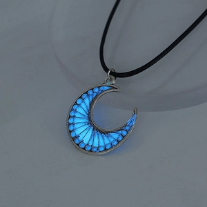 Close-up of glowing blue crescent moon pendant necklace with silver alloy frame in dark