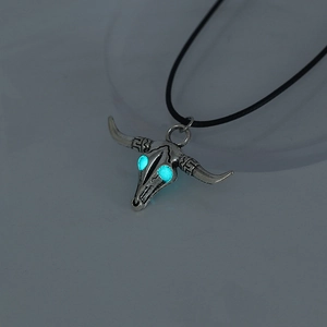 Detailed view of luminous glowing bull skull pendant with blue eyes and ethnic patterns