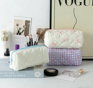 Trois trousses de maquillage matelassées à nœuds avec cosmétiques et magazines