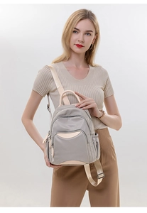 Side view of taupe nylon backpack on model showing adjustable beige straps and pockets