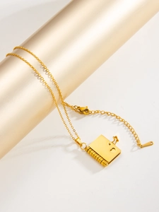 Detail of gold heart book pendant with spiral edge on thin stainless steel cross chain
