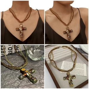 Macro shot of bohemian layered bead necklace with vintage bronze cross pendant