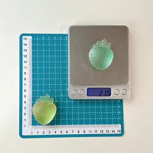 Macro shot of 4.5cm translucent green strawberry resin grip on a precision scale