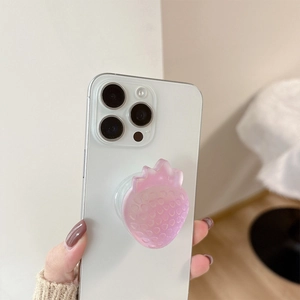 Pink strawberry pop socket with textured seeds on a white phone for cute desk decoration