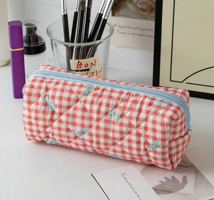Vue détaillée du sac à cosmétiques matelassé à carreaux rouges et blancs avec nœuds