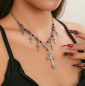 Gothic silver necklace with cross pendants and red beads worn by a model