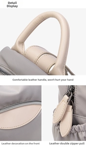 Detail of dark grey nylon backpack featuring soft leather handles and double leather zippers