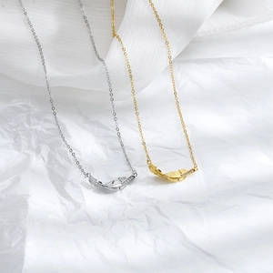 Detail of gold and silver feather pendants with sparkling cubic zirconia on a white background