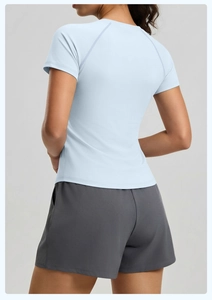 Vue arrière du t-shirt de yoga bleu clair à manches raglan et short de sport gris