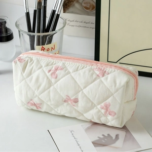 Trousse à maquillage matelassée crème avec motifs nœuds roses et fermeture éclair