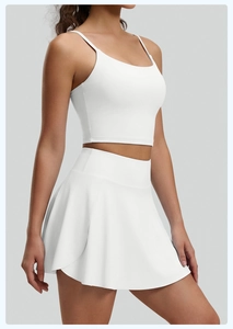 Vista lateral de camiseta blanca de yoga sin espalda y falda deportiva plisada