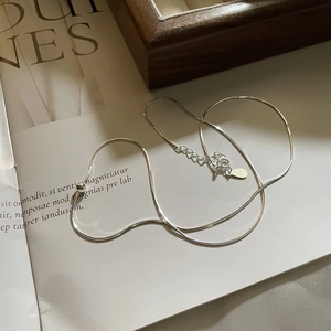 Elegant S925 sterling silver bead snake chain necklace displayed on an open magazine