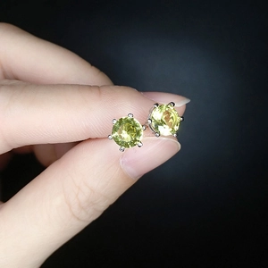 Macro shot of 6mm six-prong round stud earrings with light yellow zircon stones