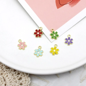 Close-up view of colorful enamel flower charms in various shades for DIY jewelry making accessories
