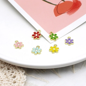 Macro view of six colorful enamel flower charms used for creative DIY jewelry making