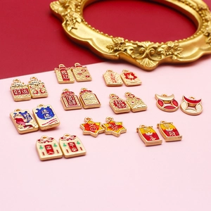 Detailed view of traditional Chinese style gold alloy charms featuring auspicious enamel text.